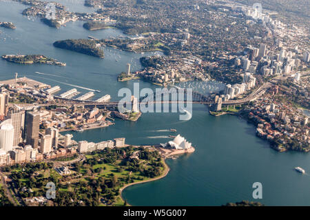 Vista aerea di Sydney di punti di riferimento: North Shore, Circular Quay, Harbour Bridge, Opera House e immediatamente al di sotto, il Giardino Botanico di Sydney, Nuovo S Foto Stock