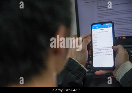 Un insegnante utilizza l'App che consente il tracciamento delle presenze degli studenti sul suo smartphone in una classe a Hangzhou dianzi University di Hangzhou, Oriente Cina Foto Stock