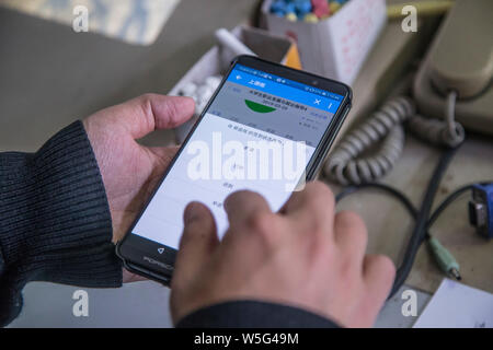 Un insegnante utilizza l'App che consente il tracciamento delle presenze degli studenti sul suo smartphone in una classe a Hangzhou dianzi University di Hangzhou, Oriente Cina Foto Stock