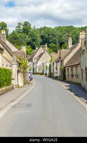 La strada a Castle Combe, Wiltshire, con visitatori godere dell'incantevole cottage in pietra Foto Stock