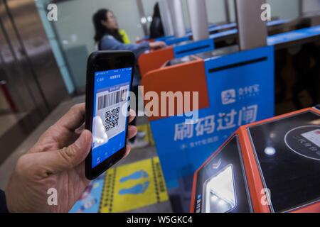 --FILE--un passeggero mette il suo smartphone al di sopra di un tornello per avere il codice QR tramite Alipay di Alibaba gruppo sottoposto a scansione per immettere la Guangzhou East railway Foto Stock