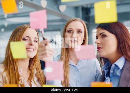 Creative team femminile in ufficio a lavorare sulla nuova strategia Foto Stock