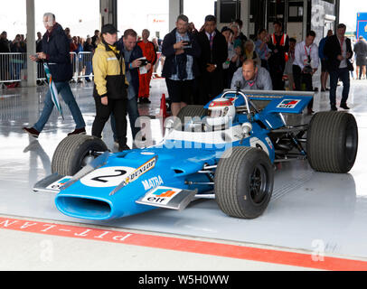 Sir Jackie Stewart essendo spinto in pit lane, nell'abitacolo della sua 1969 vincente Matra MS80-02, prima del completamento di alcuni ad alta velocità a giri intorno a Silverstone Foto Stock