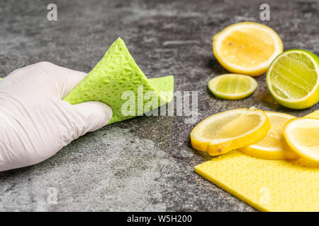La mano è la pulizia della tabella con il limone biologico agenti di pulizia Foto Stock