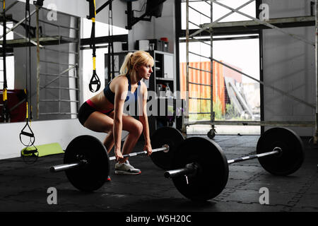 Femmina weightlifter preparando per un deadlift Foto Stock