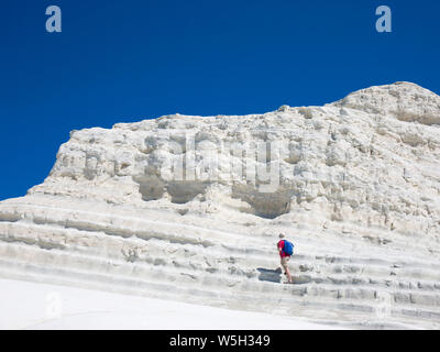 Visitatore salendo le bianche scogliere calcaree della Scala dei Turchi, Realmonte, Porto Empedocle, Agrigento, Sicilia, Italia, Mediterraneo, Europa Foto Stock