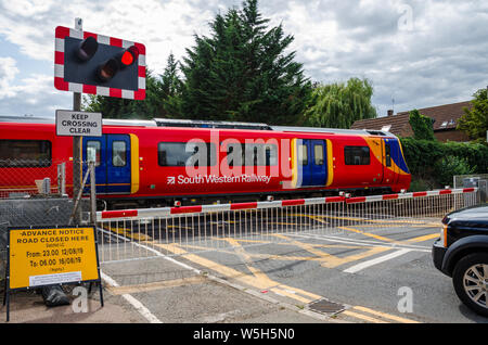 A South Western Railway treno passa attraverso un passaggio a livello a Datchet in Berkshire, Regno Unito Foto Stock