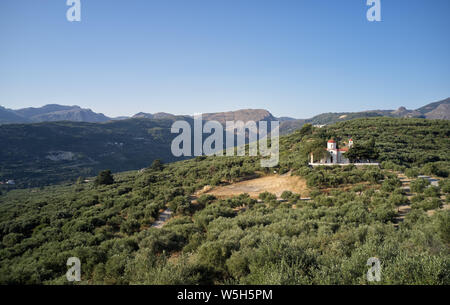 Campagna greca vista aerea da fuco. I cristiani ortodossi chiesa vicino villaggio Voulgaro. La chiesa sorge su di una collina ed è circondato da uliveti. Foto Stock