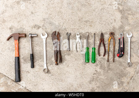 Molti strumenti carftsman che vengono collocati sul pavimento di cemento. Foto Stock