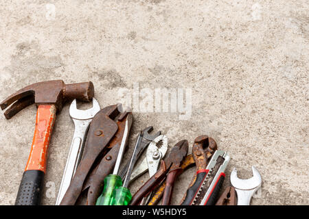 Molti strumenti carftsman che vengono collocati sul pavimento di cemento. Foto Stock