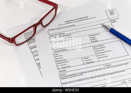 Penna e occhiali posti sulla domanda di lavoro documento, sotto forma di applicazione del concetto. Foto Stock