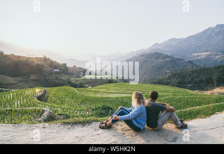 Giovane coppia caucasica guarda alle terrazze di riso di Sapa al tramonto in Lao Cai regione del Vietnam Foto Stock