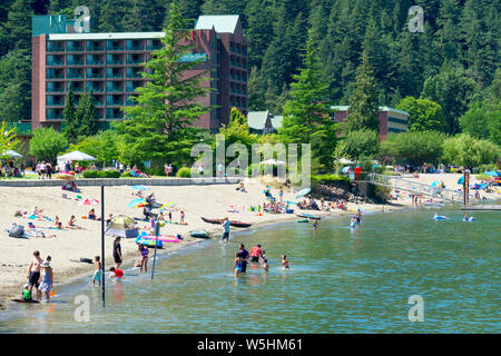 L'hotel presso l'Harrison Hot Springs Resort and Spa con gli amanti della spiaggia che si godono la spiaggia di sabbia su un caldo 28 luglio 2019. Situato sul lago Harrison, B. C. Foto Stock