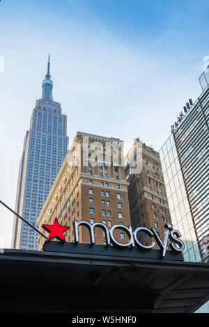 New York shopping, vista di un Macy's segno sulla West 34th Street con la mitica Empire State building in distanza, New York City, Stati Uniti d'America Foto Stock