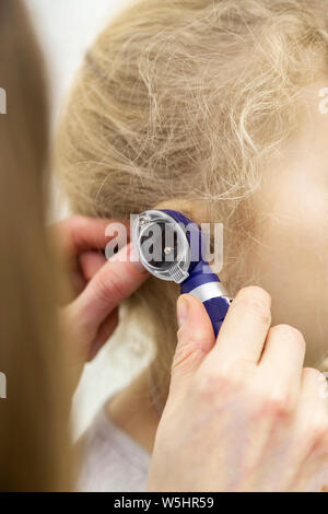 Il medico applica l'otoscopio per l'orecchio. prova di audizione con uno speciale dispositivo Foto Stock