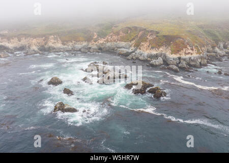 Visto dall'occhio di un uccello, l'Oceano Pacifico lavaggi contro la Scenic e rocciosa costa sud di Monterey in California del Nord. Foto Stock