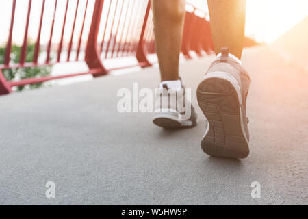 Scarpe sportive di black runner nel sole illumina Foto Stock