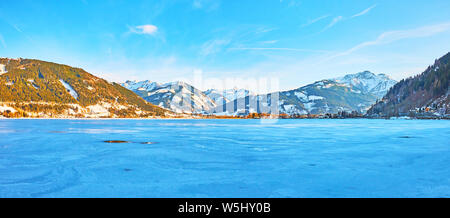 La pittoresca inverno la superficie del lago Zeller See con fori di ghiaccio e i modelli di neve sul ghiaccio, Zell am See, Austria Foto Stock