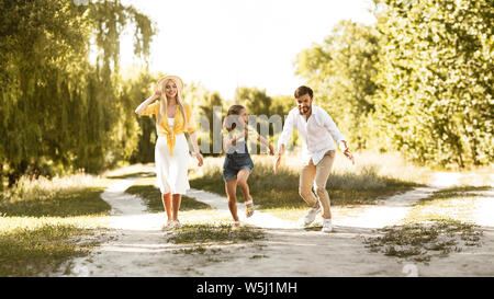 Ragazza che corre dal padre di trascorrere del tempo in campagna Foto Stock