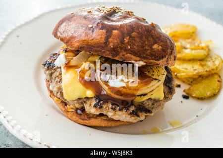 Hamburger fatti in casa con il formaggio Cheddar e le cipolle caramellate. Fast Food. Foto Stock