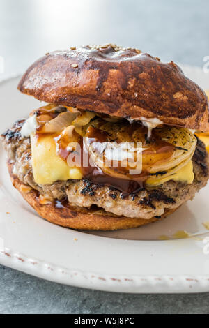 Hamburger fatti in casa con il formaggio Cheddar e le cipolle caramellate. Fast Food. Foto Stock