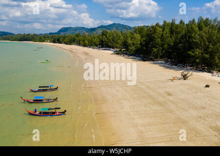 Vista aerea di legno tradizionali barche Longtail ormeggiato a una tranquilla spiaggia sabbiosa tropicale Foto Stock