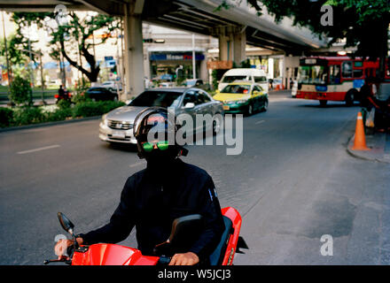 Uomo in verde occhiali da sole sulla Sukhumvit di Bangkok in Thailandia nel sud-est asiatico in Estremo Oriente. Surrealismo surreale Foto Stock