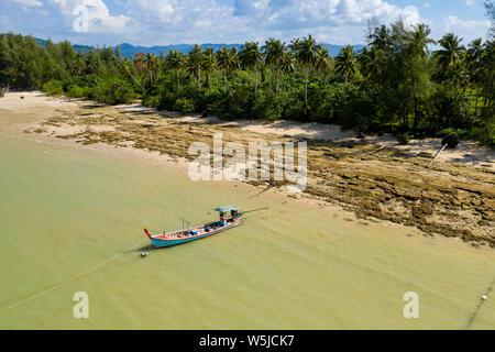 Vista aerea di un colorato tailandese tradizionale longtail boat ormeggiato a una piccola spiaggia di sabbia a Khao Lak Foto Stock