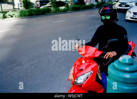 Uomo in verde occhiali da sole sulla Sukhumvit di Bangkok in Thailandia nel sud-est asiatico in Estremo Oriente. Surrealismo surreale Foto Stock