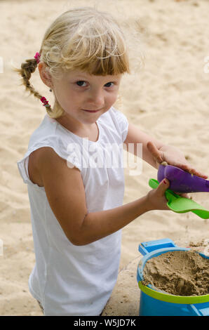 Bella ragazza bionda giocando sul parco giochi Foto Stock