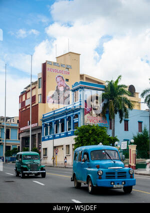 Due classici di van-come le jeep auto per le strade di Santiago de Cuba passato murali di Fidel Castro e Camilo Cienfuegos