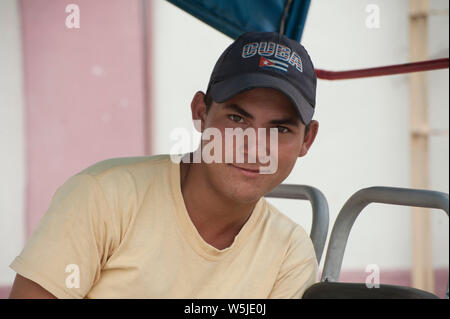 I giovani cubani taxi bicicletta chauffeur si rilassa sulla sua bicicletta Foto Stock