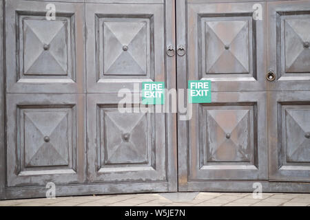 La targa "Fire exit' su massicce porte in legno Foto Stock