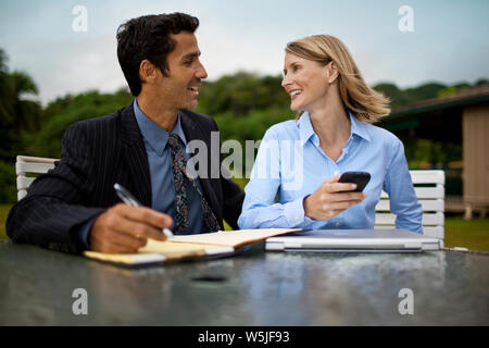 Due partner commerciali la compilazione di documenti cartacei. Foto Stock