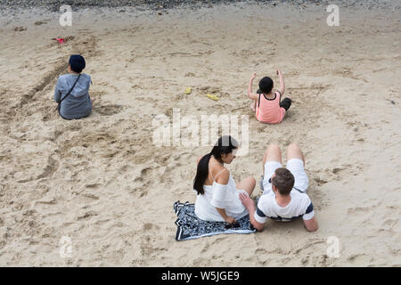 Una giovane coppia relax su un giorno d'estate sulla spiaggia a Londra il South Bank, accanto al Fiume Tamigi. Foto Stock