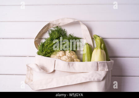 Lay piatto di verdure fresche in eco riutilizzabile zero rifiuti tessili borsa shopping su sfondo bianco, orientamento orizzontale. Foto Stock