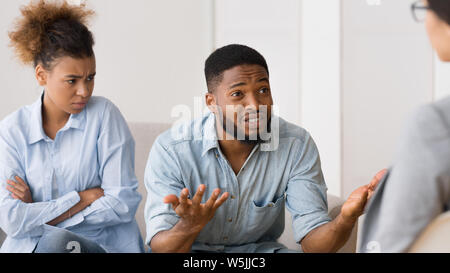 African American giovane a parlare con lo psicologo durante la sessione di terapia Foto Stock