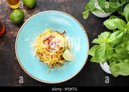 La cucina tradizionale italiana, spaghetti alla carbonara con salsa cremosa, pancetta e formaggio parmigiano Foto Stock