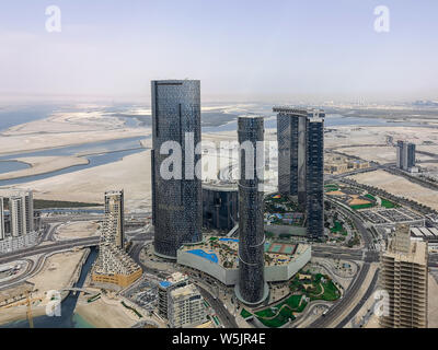 Antenna fuco shot di Al Reem island Gate Towers, sole e cielo e torri - Abu Dhabi punti di riferimento della città Foto Stock