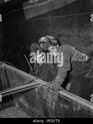 Due saldatori asta aiutando a costruire navi Liberty Frederick Douglass, Cantieri Navali Bethlehem-Fairfield, Baltimore, Maryland, Stati Uniti d'America, Roger Smith, U.S. Ufficio di informazione di guerra, Maggio 1943 Foto Stock