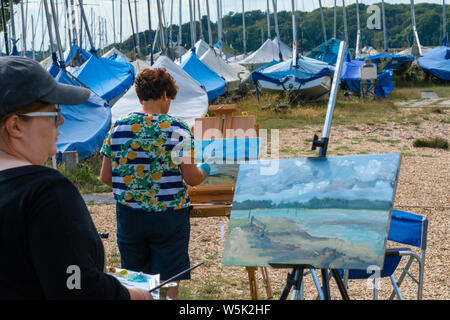 Gruppo dilettante di artisti con un tutor, dipingendo ' EN plein air' nella Marina di Chichester di scene attraverso il Canale del Quay e il Porto di Chichester Foto Stock