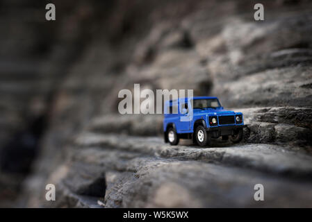 Izmir, Turchia - 28 Luglio 2019: Suv blu che è un vecchio stile sulle rocce e posare il lato anteriore destro Foto Stock