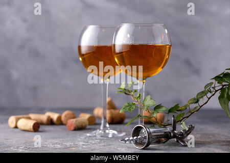 Vino bianco in un bicchiere. Il concetto di vinificazione. Posizionare sotto il vostro testo. Ancora vita su un tessiturali sfondo. Close-up. Foto Stock