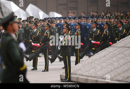 Cinese soldati PLA di accompagnare i resti di dieci soldati cinesi uccisi nel 1950-53 guerra coreana durante una cerimonia di sepoltura a uno dei martiri park di Shen Foto Stock