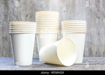 Pila di un bianco styrofoam tazze sul tavolo in legno sfondo a parete Foto Stock