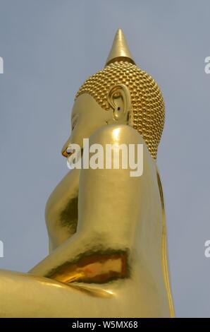 La vista laterale di un dorato statua del Buddha prese a Wat Huay Monkol in Hua Hin, Thailandia. Foto Stock