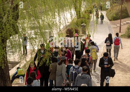 I residenti locali che indossano maschere viso contro l' inquinamento atmosferico a piedi su una strada di polveri pesanti a Pechino, in Cina, il 5 aprile 2019. Foto Stock