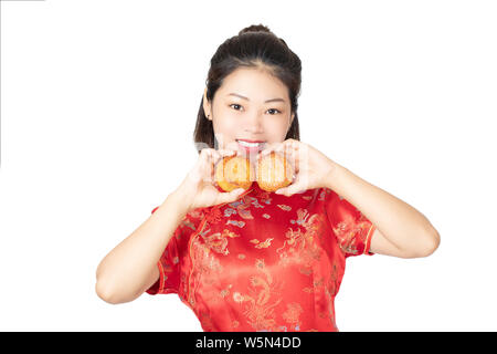 Bella donna cinese che indossa un Cheongsam o Chipao tenendo la torta della luna il cibo tradizionale della vacanza cinese di metà autunno Festival o isolato Foto Stock