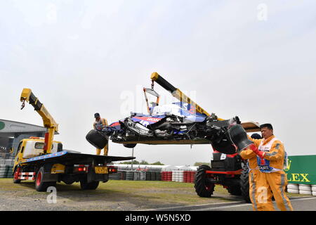 Lavoratori cerca di eliminare la vettura dopo Thai-British racing driver Alexander Albon della Scuderia Toro Rosso schiacciate durante l'ultima sessione di prove fo Foto Stock