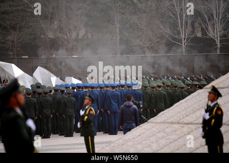 Cinese soldati PLA di accompagnare i resti di dieci soldati cinesi uccisi nel 1950-53 guerra coreana durante una cerimonia di sepoltura a uno dei martiri park di Shen Foto Stock